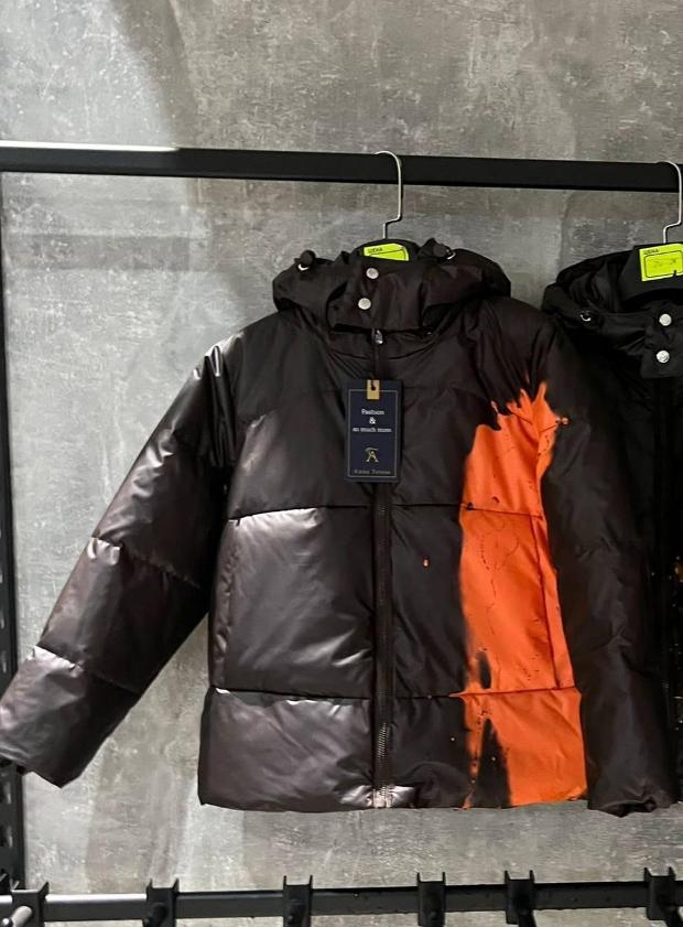 Черный пуховик с оранжевым принтом